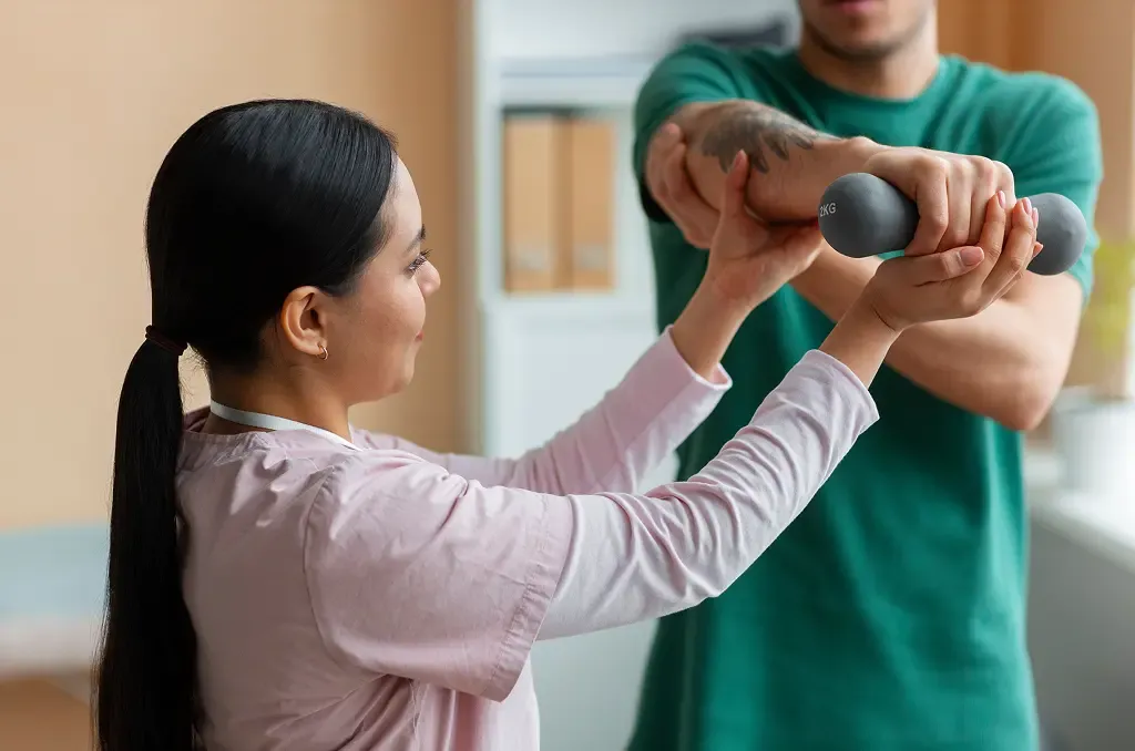Occupational therapist helping adult patient with hand exercises